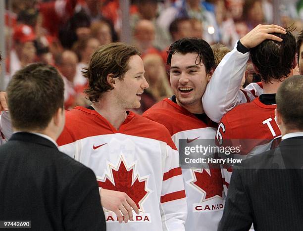 Duncan Keith and Drew Doughty of Canada smile and celebrate with teammates and coaches after winning their ice hockey men's gold medal game against...