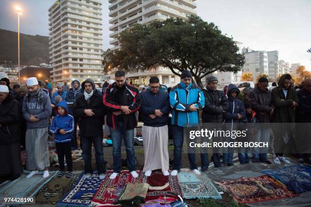 Muslim men pray at Seapoint Promenade, a popular public area next to the sea, before trying to sight the new moon, which will signify the end of the...