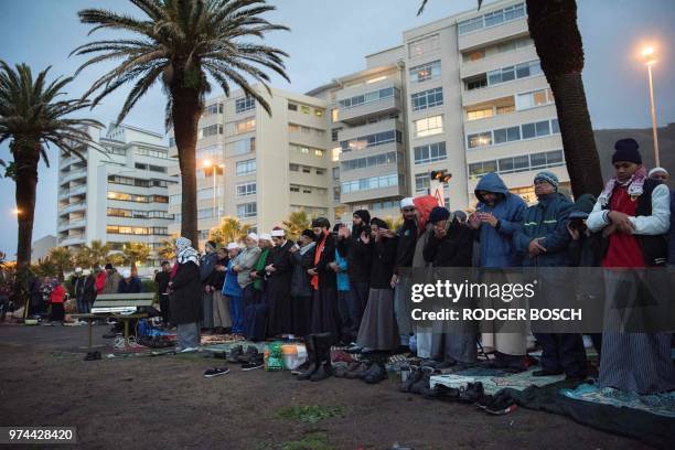 Muslim men pray at Seapoint Promenade, a popular public area next to the sea, before trying to sight the new moon, which will signify the end of the...