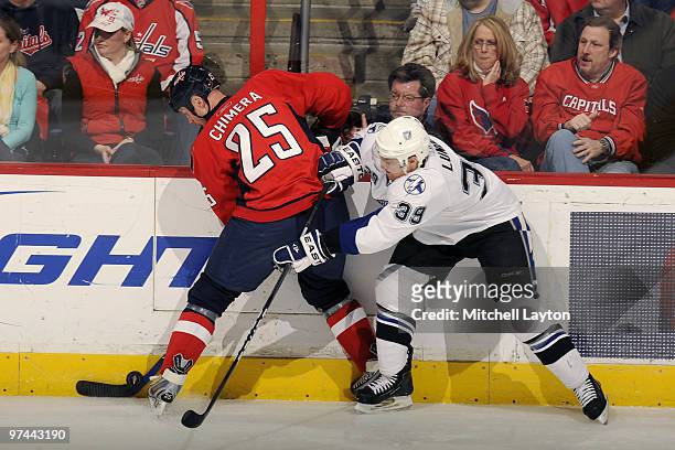 Jason Chimera of the Washington Capitals fights for a loose puck during a NHL hockey game against Mike Lundin of the Tampa Bay Lightning on March 4,...
