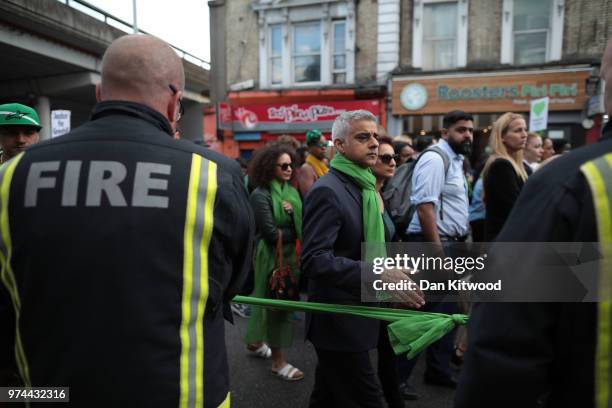 London Mayor Sadiq Khan greets firefighters during a silent march to St Marks Park where an open Iftar will take place on the one year anniversary...