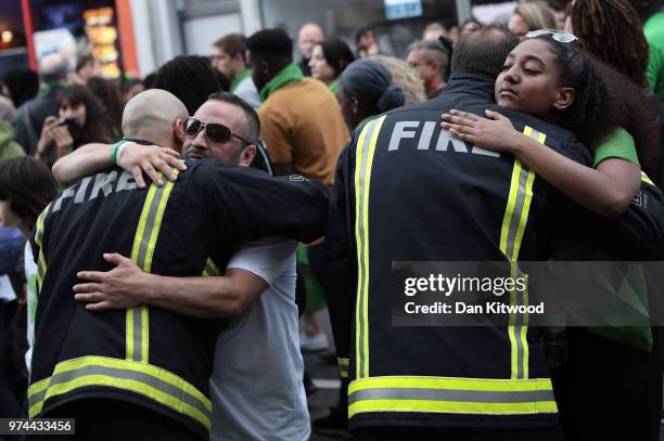 People stop to hug firefighters during a silent march to St Marks Park where an open Iftar will take place on the one year anniversary of the...