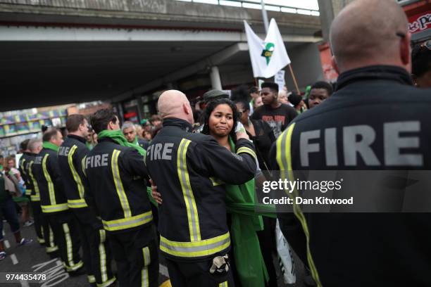 People stop to hug firefighters during a silent march to St Marks Park where an open Iftar will take place on the one year anniversary of the...