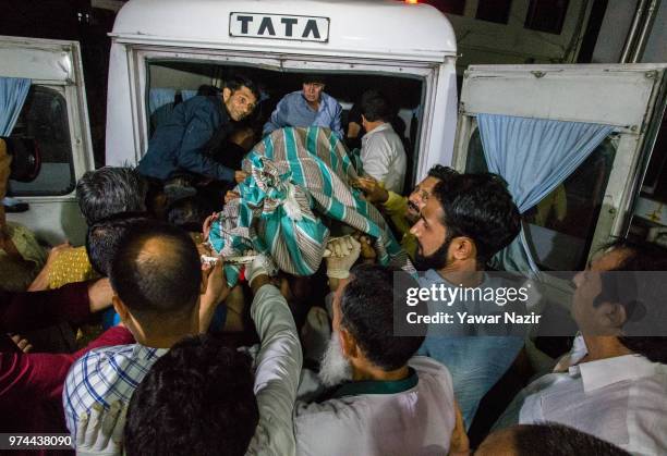 People carry the body of Syed Shujaat Bukhari, the editor of Rising Kashmir daily newspaper, who was killed by unidentified gunmen outside his office...