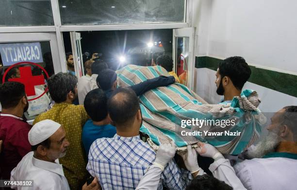 People carry the body of Syed Shujaat Bukhari, the editor of Rising Kashmir daily newspaper, who was killed by unidentified gunmen outside his office...