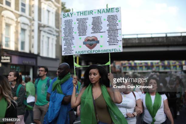 Woman holds up a placard with the 71 names of the Grenfell victims during a silent march to St Mark?s Park where an open Iftar will take place on the...