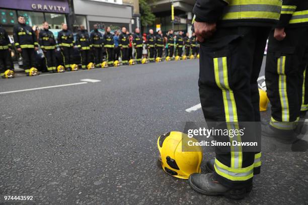 Firefighters line the street during a silent march to St Marks Park where an open Iftar will take place on the one year anniversary of the Grenfell...