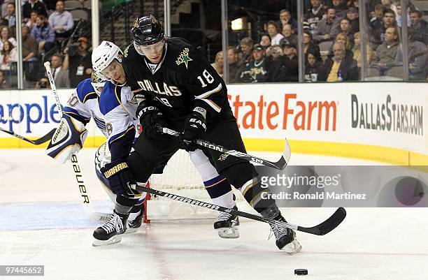 Left wing James Neal of the Dallas Stars skates the puck against Jay McClement of the St. Louis Blues at American Airlines Center on March 4, 2010 in...