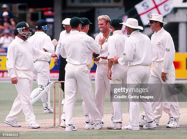 Shane Warne of Australia is congratulated by team-mates during a test match.