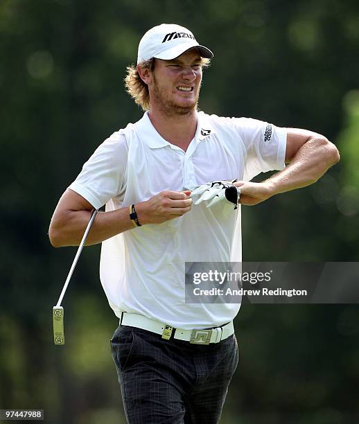 Chris Wood of England takes off his glove on the first hole during the the second round of the Maybank Malaysian Open at the Kuala Lumpur Golf and...