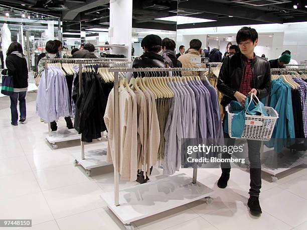 Customers shop at a Fast Retailing Co. Uniqlo store in Tokyo, Japan, on Friday, March 5, 2010. Fast Retailing Co., Japan's largest clothing retailer,...