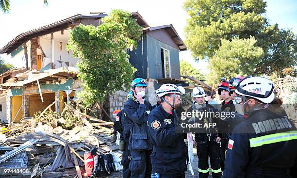 Firefighters organize a search in a devastated area of Constitucion, some 300 km south of Santiago, March 4, 2010. The official death toll from...