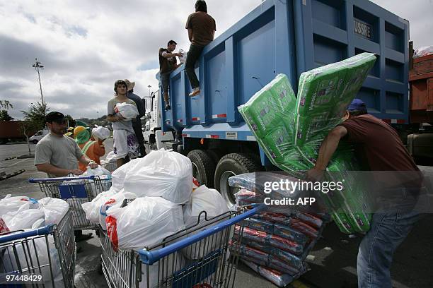 Volunteers load a lorry with relief aid at a humanitarian aid center in Concepcion, Chile on March 04, 2010. The official death toll from Saturday's...