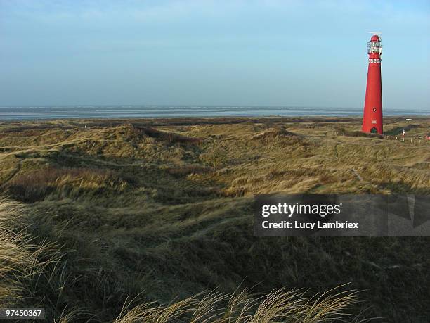 red lighthouse in dunes - lucy lambriex stock-fotos und bilder