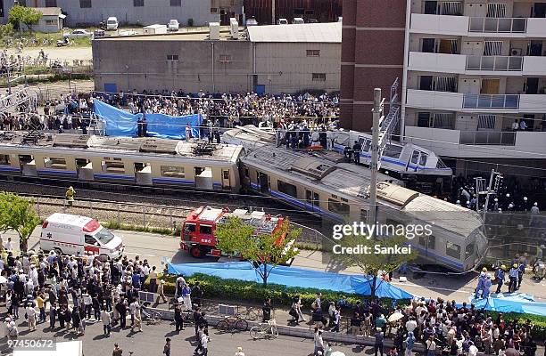 Rescue workers attempt to free trapped passengers from a crushed commuter train after it derailed and ploughed into an apartment building on April...