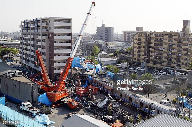 Rescue work continues to free trapped passengers from a crushed commuter train after it derailed and ploughed into an apartment building on April 28,...