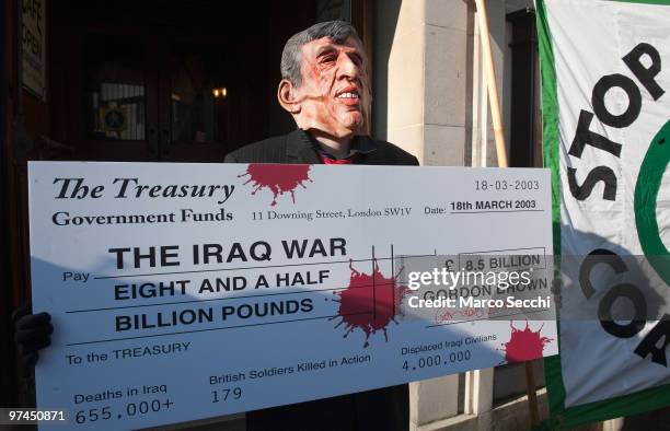 Protestor hold a giant cheque while Prime Minister Gordon Brown arrives at the Iraq Inquiry on March 5, 2010 in London, England. Mr Brown will face...