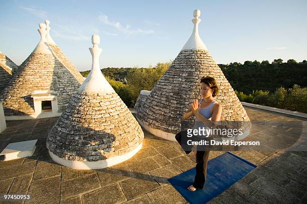 woman practicing yoga - cisternino stock-fotos und bilder
