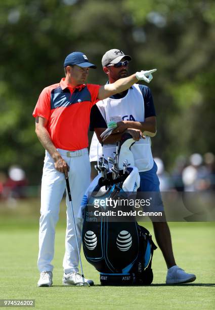 Jordan Spieth of the United States waits to play his second shot on the third hole with his caddie Michael Greller during the first round of the 2018...