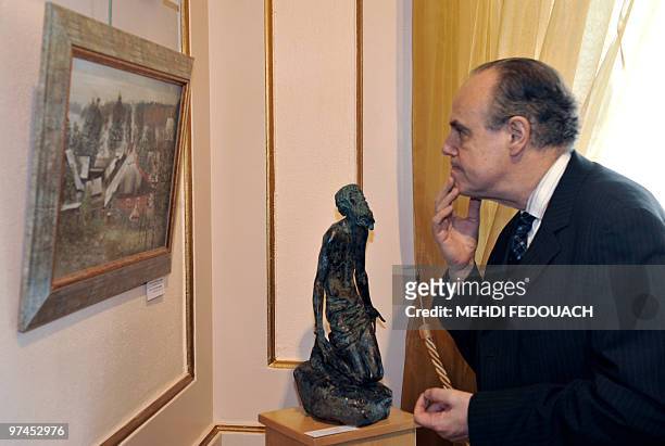 French Culture Minister Frederic Mitterrand watches a painting as he visits with Russian first lady Svetlana Medvedeva the exhibition called "A...