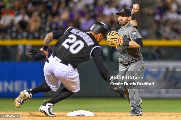 Daniel Descalso of the Arizona Diamondbacks throws to first base over Ian Desmond of the Colorado Rockies to complete a double play to end the eighth...