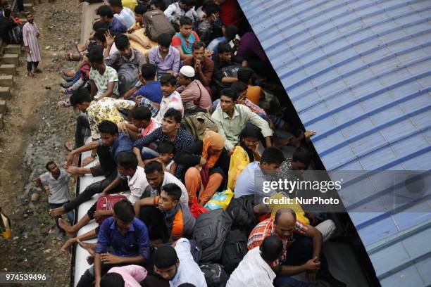 Bangladeshi people rush to homes on an overcrowded train to celebrate upcoming Eid-al-Fitr festival in Dhaka, Bangladesh on June 14, 2018. Muslims...