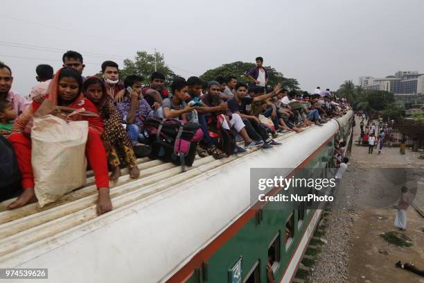 Bangladeshi people rush to homes on an overcrowded train to celebrate upcoming Eid-al-Fitr festival in Dhaka, Bangladesh on June 14, 2018. Muslims...