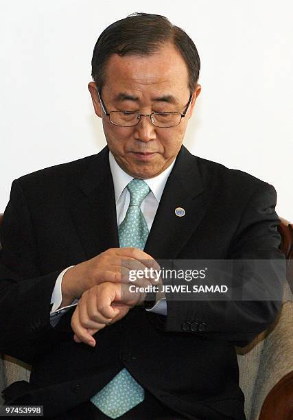 Secretary General Ban Ki-moon checks the time as he waits for a meeting with Australia's Prime Minister Kevin Rudd before the start of the high-level...