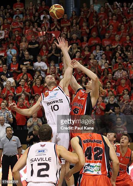 Larry Davidson of the Hawks and Luke Schenscher of the Wildcats contest the jump ball during game one of the NBL Grand Final Series between the Perth...