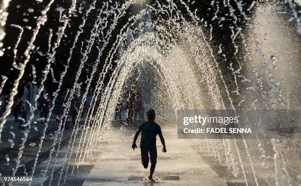 Child plays in a fountain in Voronezh on June 14 during the Russia 2018 World Cup football tournament.