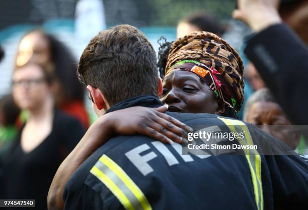 People stop to hug firefighters during a silent march to St Marks Park where an open Iftar will take place on the one year anniversary of the...