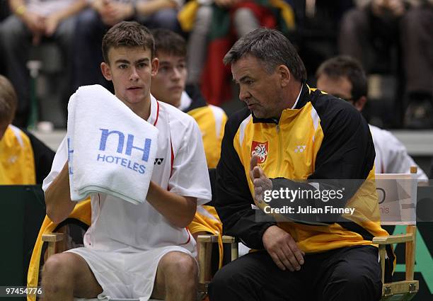 Lituania Captain Remigijus Balzekas gives his support as Laurynas Grigelis of Lithuania plays James Ward of Great Britain during day one of the Davis...