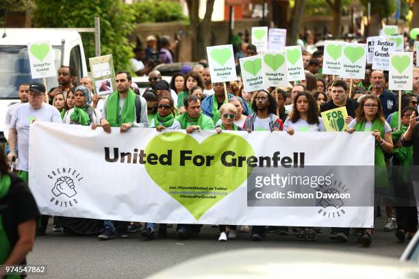 People with placards and a banner which says "United For Grenfell" take part in a silent march to St Marks Park where an open Iftar will take place...