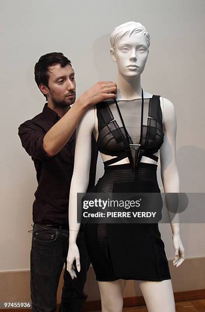 Italian designer Anthony Vaccarello adjusts the strap of one of his creations displayed on a mannequin during the autumn-winter 2010 pret-a-porter...