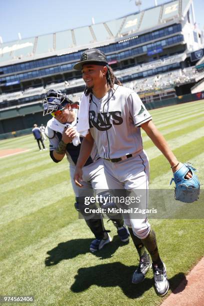 Jesus Sucre and Chris Archer of the Tampa Bay Rays stand on the field wafter warming up in the bullpen prior to the game against the Oakland...