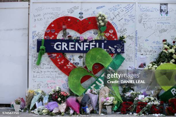 Members of the public lay tributes at a memorial at the base of the Grenfell Tower as part of commemorations on the first anniversary of the Grenfell...