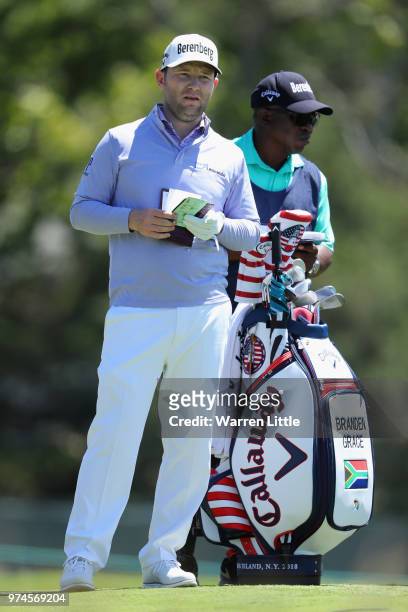 Branden Grace of South Africa and caddie Zacharia Rasego wait on the sixth tee during the first round of the 2018 U.S. Open at Shinnecock Hills Golf...