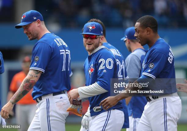 Josh Donaldson of the Toronto Blue Jays celebrates their victory with John Axford and Curtis Granderson in the tenth inning during MLB game action...