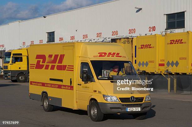 Delivery truck passes DHL shipping containers at a package sorting center in Cologne, Germany, on Thursday, March 4, 2010. Deutsche Post AG releases...