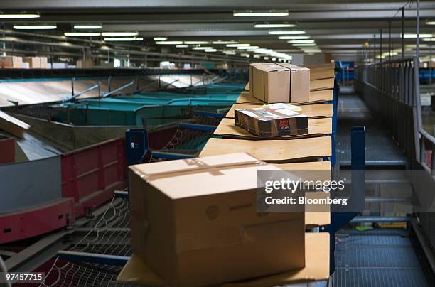 Parcels are processed through a sorting machine at a DHL package sorting center in Cologne, Germany, on Thursday, March 4, 2010. Deutsche Post AG...