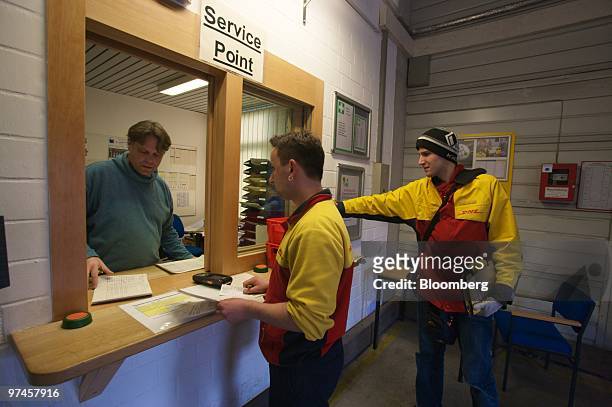 Delivery employees check in at a DHL package sorting center in Cologne, Germany, on Thursday, March 4, 2010. Deutsche Post AG releases its earnings...