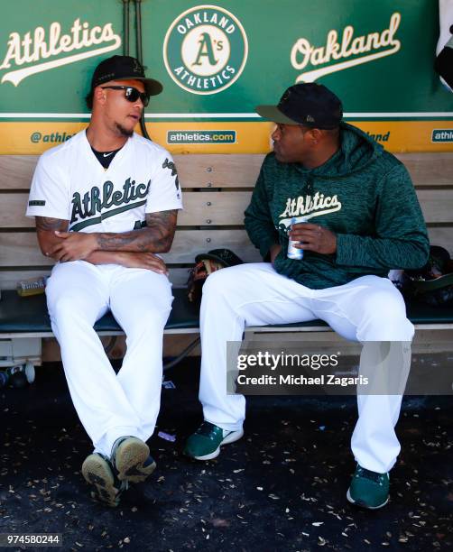 Frankie Montas and Santiago Casilla of the Oakland Athletics talk in the dugout during the game against the Tampa Bay Rays at the Oakland Alameda...