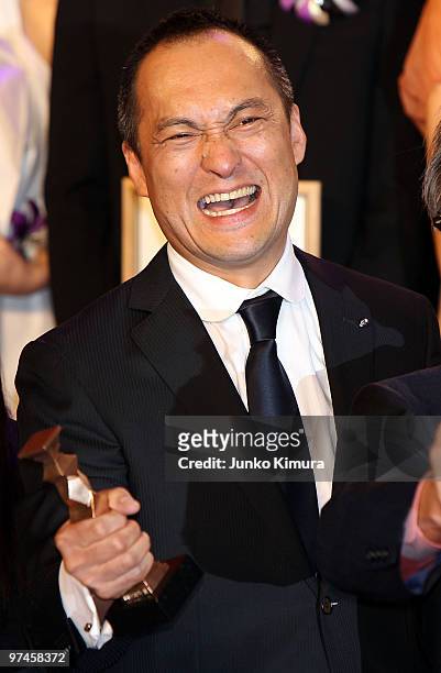 Actor Ken Watanabe holds a trophy upon receiving the award for the best actor in a leading role for the film "Shizumanu Taiyou" during the 33rd Japan...