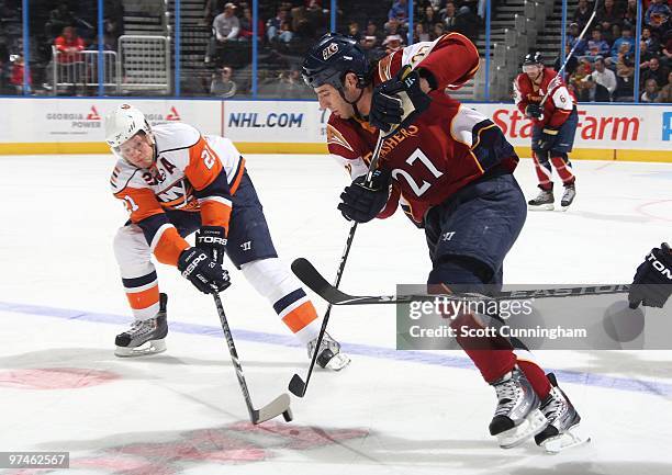 Kyle Okposo of the New York Islanders battles for the puck against Chris Thorburn of the Atlanta Thrashers at Philips Arena on March 4, 2010 in...