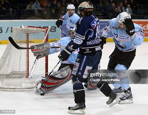 Robert Goepfert and Alexander Dotzler of Hamburg challenge Daniel Sparre of Iserlohn during the DEL match between Hamburg Freezers and Iserlohn...