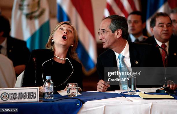 Secretary of State Hillary Rodham Clinton reacts after seeing the ceiling ornamentation, next to Guatemalan President Alvaro Colom, during a working...