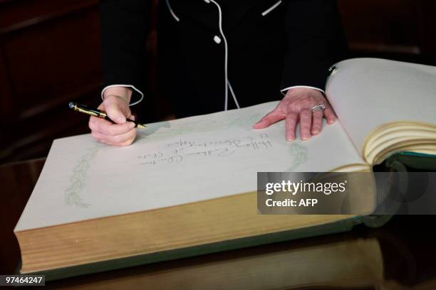 Secretary of State Hillary Rodham Clinton, signs a guest book during her meeting with Guatemalan President Alvaro Colom , at the National Palace of...