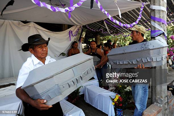 Relatives carry coffins with the remains of 26 members of the Aleman and Rivera families in the house of Domingo Aleman, before the burial in La Mora...