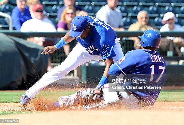 Nelson Cruz of the Texas Rangers is tagged out attempting to take third base by infielder Wilson Betemit of the Kansas City Royals during the MLB...