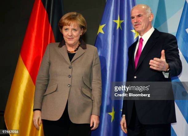 George Papandreou, prime minister of Greece, right, and Angela Merkel, Germany's chancellor, depart the podium following a news conference at the...